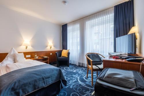 een hotelkamer met een bed en een bureau bij Hotel Gertrudenhof in Keulen