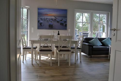a dining room with a white table and chairs at Ferienhaus Ankerplatz Vermietung im Ostseebad Rerik in Rerik