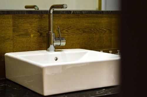 a white sink sitting next to a wooden cabinet at Aguilas5 SevillaSuites in Seville