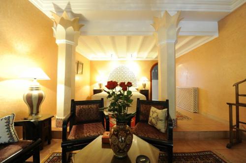 a hotel room with a vase of flowers on a table at Domaine de la Roseraie Resort in Ouirgane