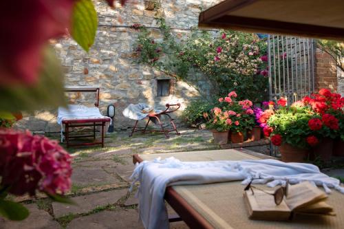 a garden with flowers and a table with a towel on it at Palazzo Malaspina B&B in Tavarnelle in Val di Pesa