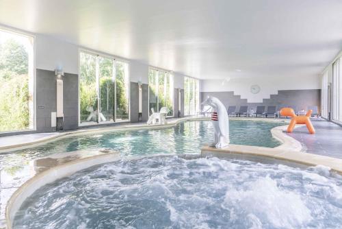 una piscina con un tobogán de agua en una casa en Le Manoir De La Poterie & Spa, en Cricquebœuf
