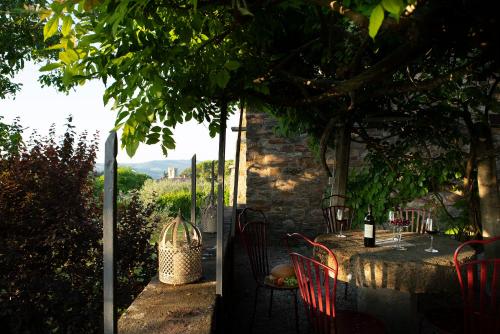 a table with chairs and a bottle of wine at Palazzo Malaspina B&B in Tavarnelle in Val di Pesa