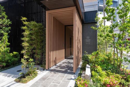 a wooden entrance to a building with plants at Hiyori Hotel Osaka Namba Station in Osaka