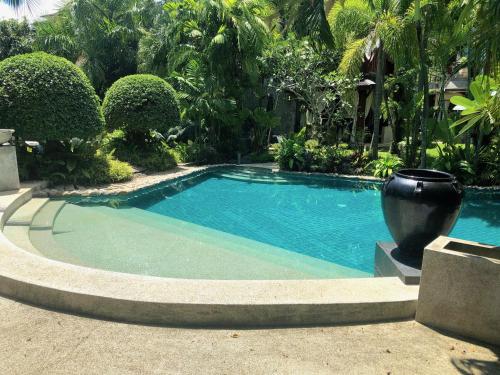 a swimming pool in a yard with a vase next to it at Villa on The Rocks, 4 bedrooms, Phuket in Surin Beach