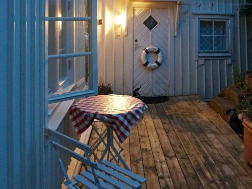 porche de madera con mesa y puerta en 4 person holiday home in GRUNDSUND, en Grundsund
