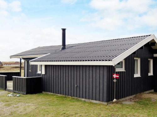 ein schwarzes Haus mit schwarzem Dach in der Unterkunft 8 person holiday home in Harbo re in Harboør