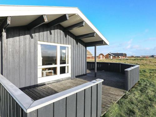 a small house with a deck and a window at 8 person holiday home in Harbo re in Harboør