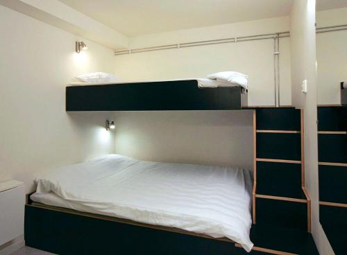 a bedroom with two bunk beds with white sheets at Citysleep in Luleå