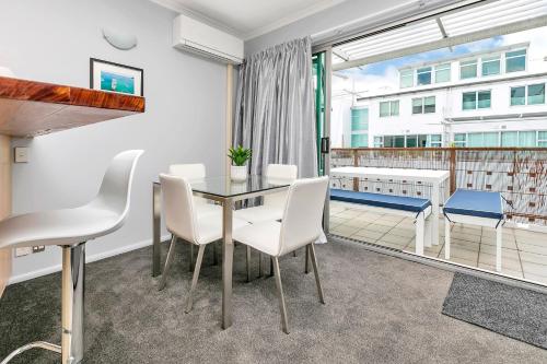 a dining room with a table and chairs and a balcony at Deluxe Princes Wharf Apt l FREE WIFI & AIRCON in Auckland