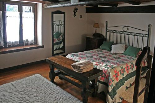 una camera con un letto, un tavolo e una panca di Monte Baserria a Ziortza-Bolibar