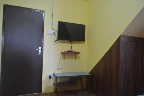 um quarto com uma televisão no canto de uma parede em Banabas Homestay em Darjeeling