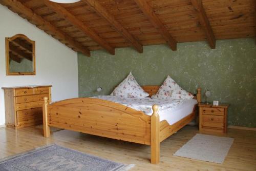 um quarto com uma cama de madeira e 2 cómodas em Ferienwohnungen Baur em Arnbruck