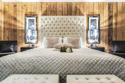 a bedroom with a large bed with two windows at SOLEA DOLOMITI Boutique Hotel in Fai della Paganella