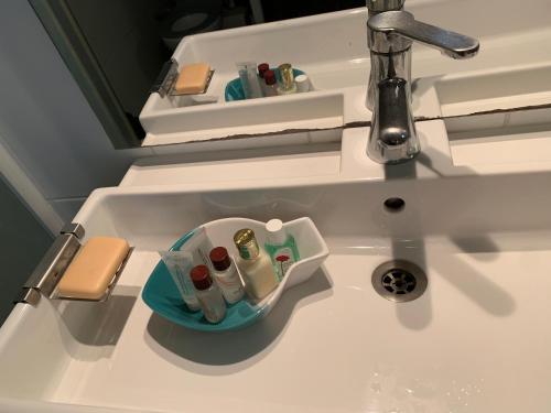 a bathroom sink with a tray of toiletries in it at Villa Soledad in Cassis