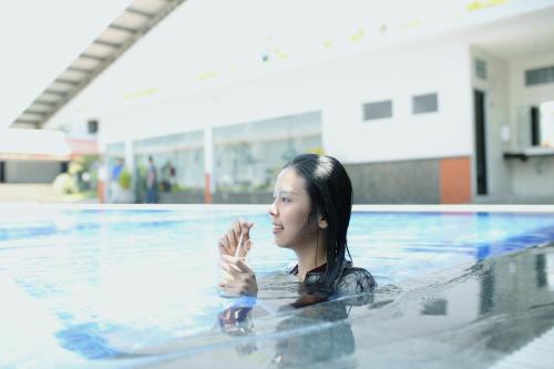 Eine Frau, die im Schwimmbad schwimmt. in der Unterkunft Aria Gajayana in Malang