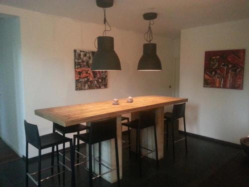 a dining room table with chairs and two lights at B & B Waalre in Waalre