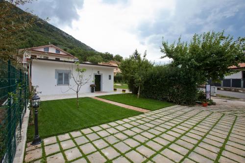 une arrière-cour avec une maison et une pelouse dans l'établissement Victoria Cottage, à Posta Fibreno