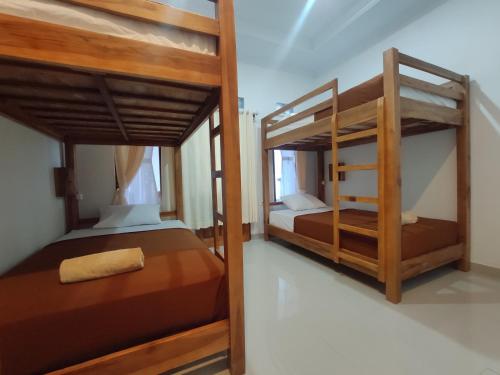 two bunk beds in a room withthritisthritisthritisthritisthritisthritisthritisthritisthritis at Gedhong Hostel in Nusa Penida