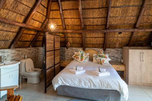 a bedroom with a bed and a toilet in a room at Lala Dene Lodge in Bloemfontein