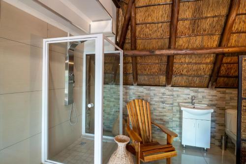 a bathroom with a wooden chair and a sink at Lala Dene Lodge in Bloemfontein