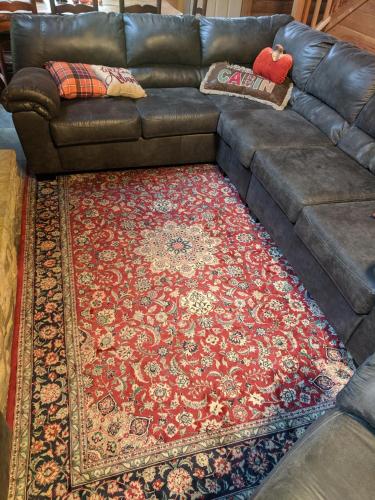 a brown leather couch with a rug on top of a rug at Smokies Overlook Lodge in Waynesville