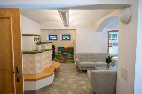 a living room with a couch and a chair at Penzion Kryštof in Kovářská