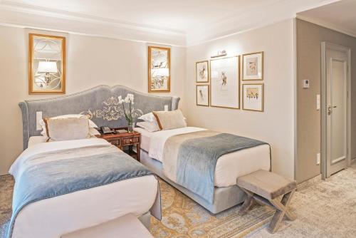 a bedroom with two beds and a chair in it at Bachleda Luxury Hotel Kraków - MGallery Collection in Kraków