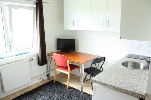 a small kitchen with a desk with a television on it at Bedder at Oslo Airport - serviced apartments in Jessheim
