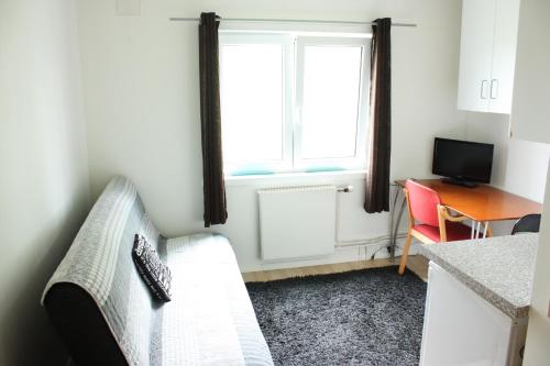 a living room with a white couch and a window at Bedder at Oslo Airport - serviced apartments in Jessheim