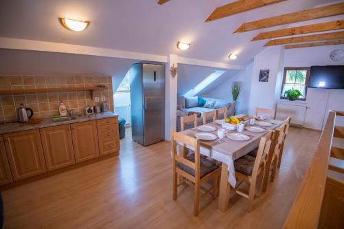 a kitchen and a dining room with a table and chairs at Penzion Kryštof in Kovářská