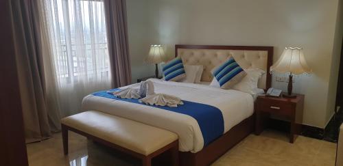 a bedroom with a large bed with blue and white pillows at Tolip Olympia Hotel in Addis Ababa