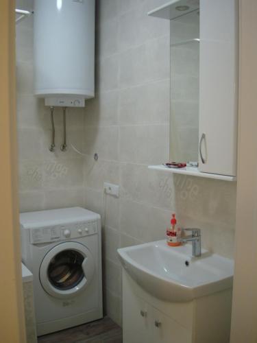 ein Badezimmer mit einer Waschmaschine und einem Waschbecken in der Unterkunft Для двоих in Odessa