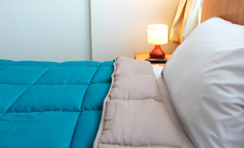 a blue and white couch in a room with a lamp at Hotel Romano in Concepción