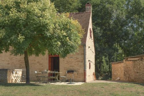 ein Gebäude mit einem Tisch und einem Baum davor in der Unterkunft Maison de Blanche in Chaudenay-le-Château