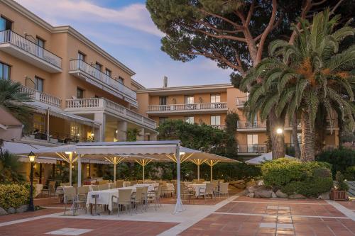 a restaurant with tables and chairs in front of a building at S'Agaró Hotel Spa & Wellness in S'Agaro