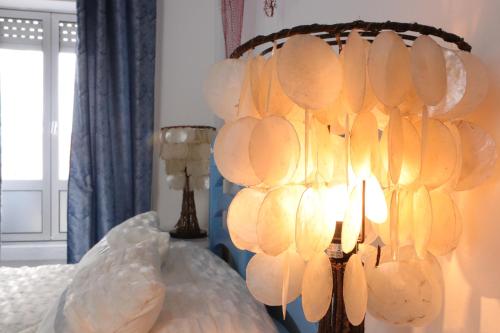 a bedroom with a bed with a chandelier at Paraíso Azul, AL in Vila Franca do Campo