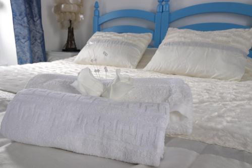 a white bed with white towels and pillows on it at Paraíso Azul, AL in Vila Franca do Campo