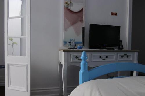 a bedroom with a bed and a tv on a dresser at Paraíso Azul, AL in Vila Franca do Campo