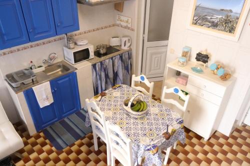 a small kitchen with a table and blue cabinets at Paraíso Azul, AL in Vila Franca do Campo