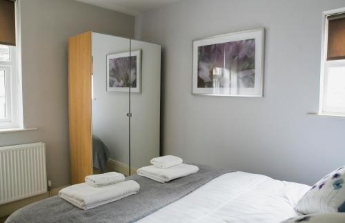 a bedroom with a bed with two white towels at Harlow apartment in Harrogate