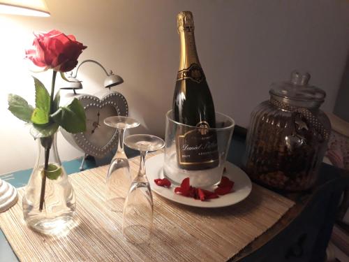 a bottle of champagne sitting on a table with wine glasses at Chambres d'hôtes La Bourbelle in Neufmoutiers-en-Brie