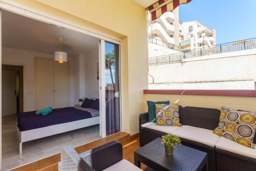 een woonkamer met een bank en een bed bij Spacious Beachfront Flat with Sea Views and Private Indoor Parking in Benalmádena