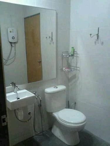 a bathroom with a white toilet and a sink at Seri Kenangan Holiday Home in Kota Samarahan