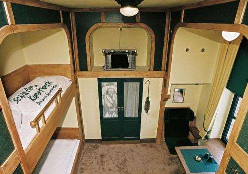 a small room with two bunk beds and a tv at Pension Spreewelten in Lübbenau