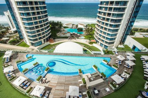 een uitzicht over een zwembad naast de oceaan bij The Capital Pearls Hotel in Durban