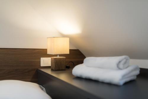 a bedroom with two beds and a table with a lamp at Garni Hotel Cirman in Ljubljana