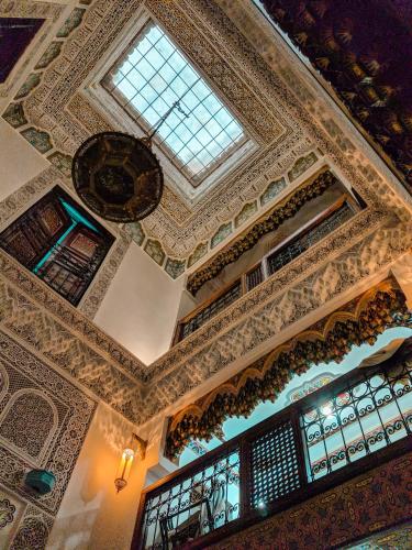 an ornate ceiling in a building with a window at Riad Fés blida in Fès