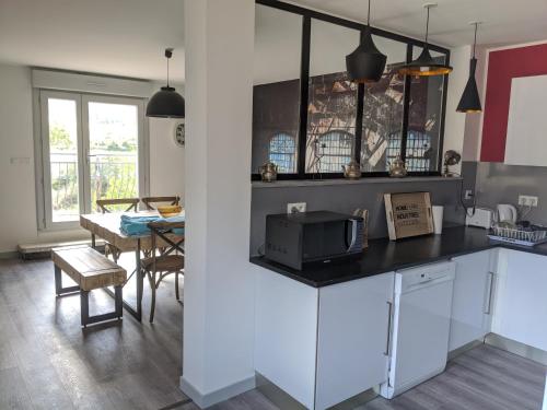 - une cuisine avec un comptoir, un four micro-ondes et une table dans l'établissement LA MAISON MIRAVA, à La Caunette