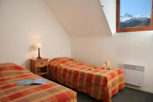 a room with two beds and a teddy bear sitting on a table at Résidence Néméa La Soulane in Loudenvielle